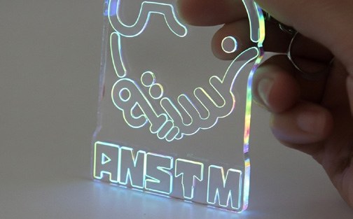 Illuminated branded acrylic item being held upright from the company profile