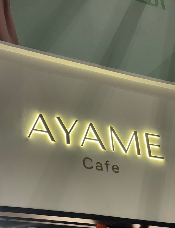 Illuminated AYAME Cafe signage shown in the Basma Paradise company profile