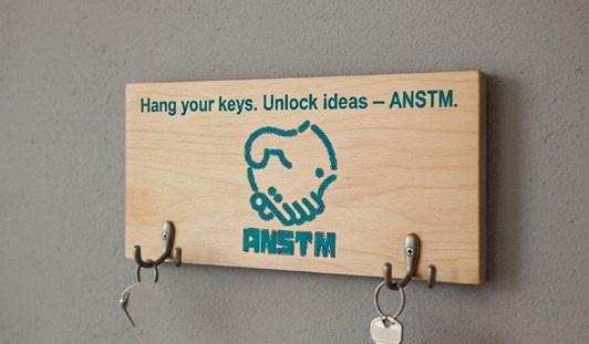 Branded wooden key holder with ANSTM logo from the company profile