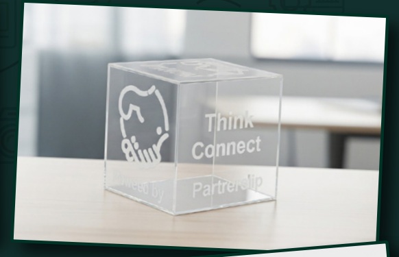 Clear acrylic cube with ANSTM branding and engraved words in the company profile — مكعب أكريليك شفاف يحمل هوية ANSTM ونصوصًا محفورة في بروفايل الشركة