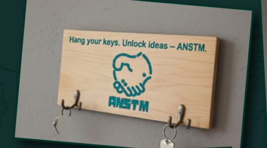 Wooden ANSTM branded wall key holder with hooks in the original company profile — حامل مفاتيح خشبي جداري بشعار ANSTM وخطافات في بروفايل الشركة الأصلي